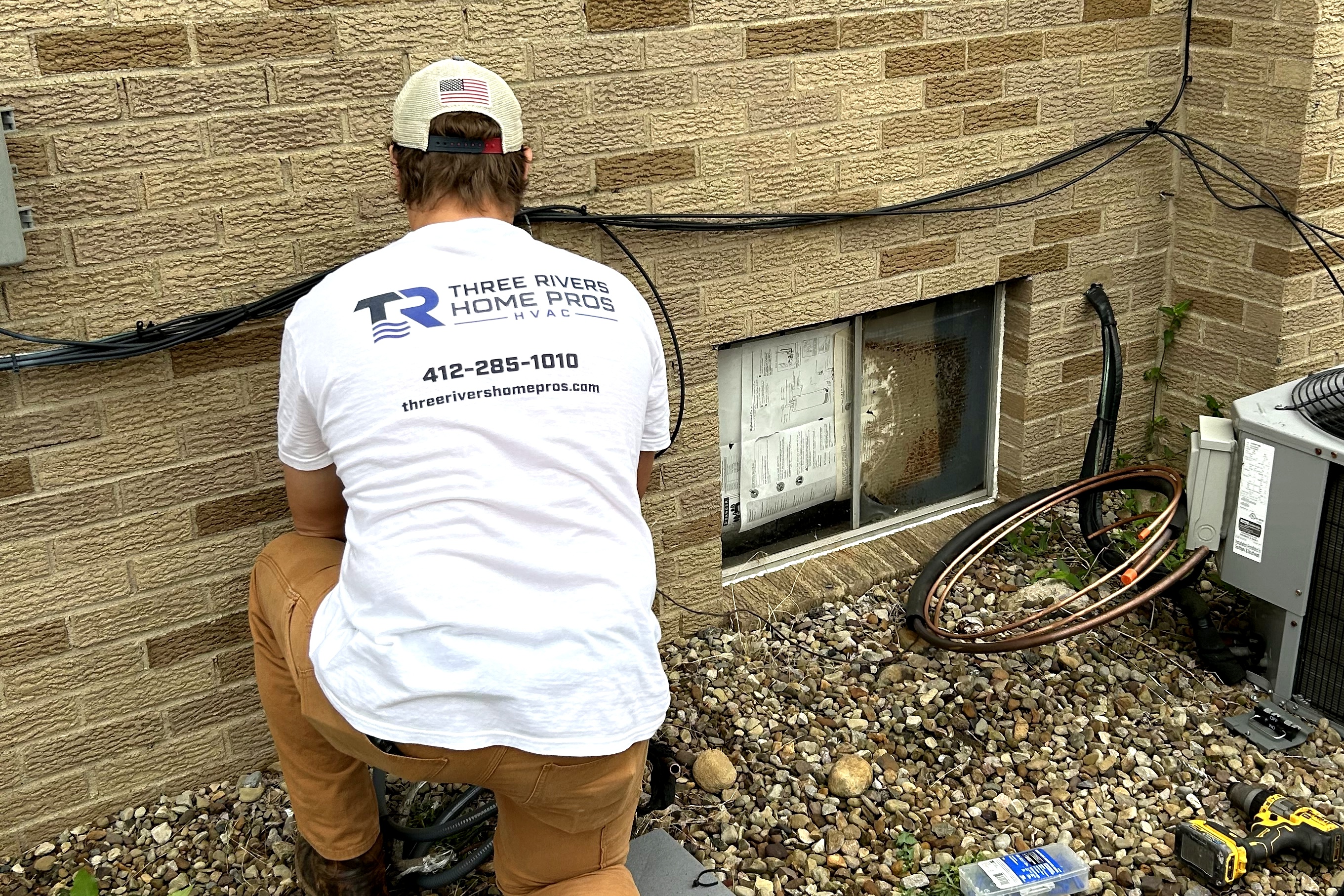 Three Rivers Home Pros technician working on an outdoor HVAC condenser unit